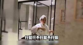 A person wearing a hooded jacket stands inside a metal-framed structure, with Chinese subtitles reading "行就行不行就不行啊" (roughly "If it works it works, if not then it doesn't"). The image's humorous, resigned tone fits the meme caption referencing Bitcoin's volatile price action.