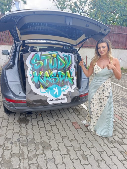 A woman in a flowing patterned dress gives a thumbs-up beside an SUV displaying a graffiti-style "STUDY KASPA" banner with the website www.kaspa.org, visually promoting the "$KAS" cryptocurrency study mission referenced in the post.