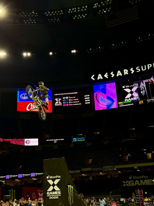 A motocross rider soars mid-air against a backdrop of X Games Minneapolis 2020 signage at Caesar's Superdome, performing a high-flying trick that mirrors the gravity-defying thrill of leaping into crypto. The "X Games" and "MoonPay" branding hint at the event's sponsors, capturing the adrenaline-fueled, spectacle-driven excitement the post evokes about entering the crypto space.