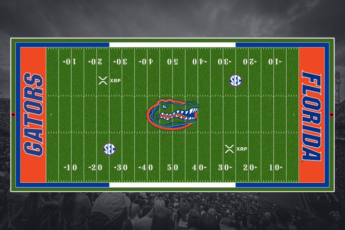 An overhead view of Florida's football field showcases the school's branding with "GATORS" and "FLORIDA" displayed in the end zones, the Gator logo at midfield, and SEC markings throughout. Two XRP logos, the cryptocurrency brand, are prominently featured at the 25-yard lines, illustrating the new on-field sponsorship deal between Florida football and Ripple.