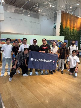A group photo of about a dozen people posing indoors while holding a banner that reads 'iP superteam'.