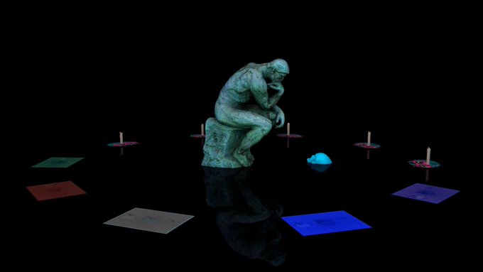 A bronze statue of 'The Thinker' sitting on a cube, surrounded by colored cards and candles on a reflective black surface.