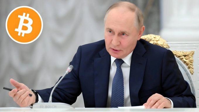 Russian President Vladimir Putin is shown seated at a desk with a Bosch microphone, with a Bitcoin logo superimposed in the top left corner, illustrating news that he has signed the first comprehensive law to manage the crypto market in Russia.