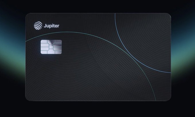 A black "Jupiter" credit card with an embedded chip is displayed against a dark background with subtle wave patterns. The image relates to the post by illustrating a potential rewards card concept that would offer VIP cashback for staked JUP tokens, similar to other perks currently offered for $XLP and $ENA.