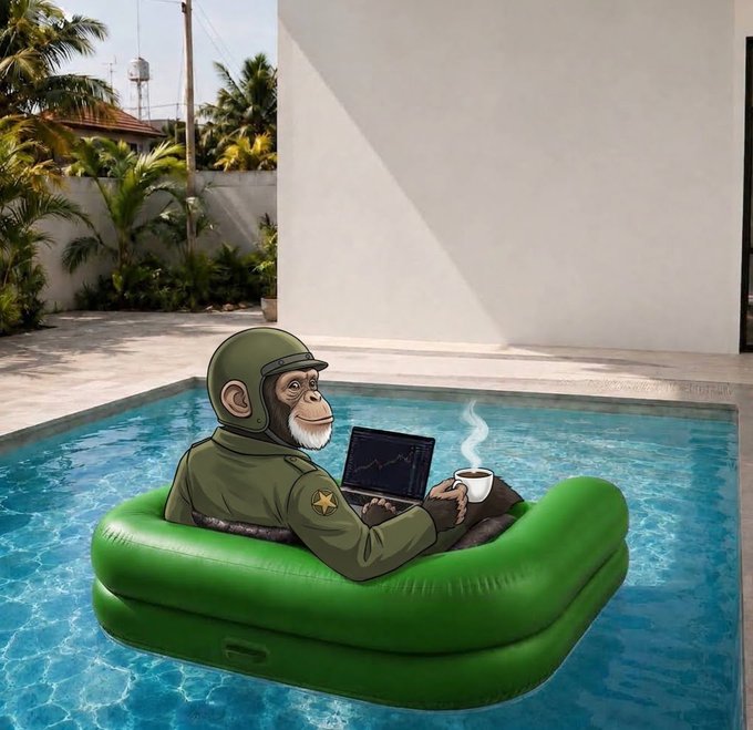 A chimpanzee wearing a green military helmet and uniform floats in a green inflatable raft in a swimming pool, holding a laptop displaying a chart and a steaming cup of coffee.
