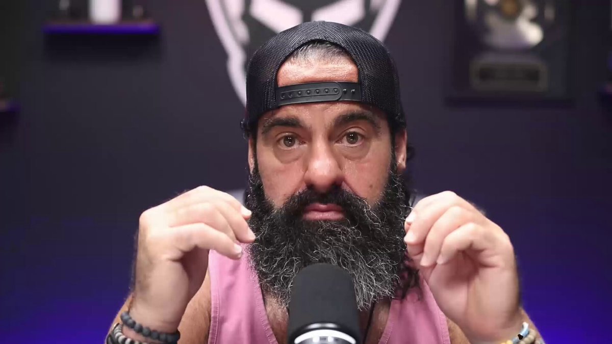 The image features a man with a beard wearing a black baseball cap, sitting behind a microphone. He has his hands on his face as if he's about to make a speech or give an interview. The caption of the image reads "XRP is at the Center of it all..." and there are two other captions in the background that read "focus on what is in the image" and "focus on how it relates to the post".
