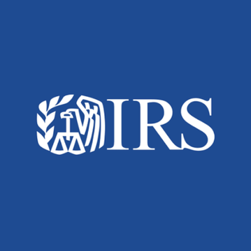 The IRS logo is displayed in white on a blue background, representing the U.S. tax agency issuing warnings about phishing schemes targeting cryptocurrency holders with fake Digital Asset Compliance notices.