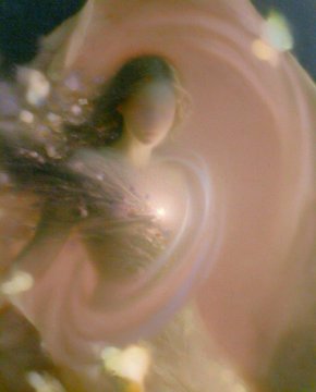 A close-up, blurry image showing a pale, curved organic shape with a dark opening in the center.