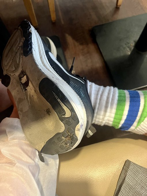 The image shows a person wearing a black Nike sneaker with white laces, sitting or lying down on a couch. The sneakers are positioned on their foot, and there's a sock visible underneath them. The photo also contains text that reads "2ヶ月でこれ。スニーカー見に行こうかな". This could be a caption for the image or part of an article about Nike shoes.

The post appears to be related to the sneaker, as it features a photo of someone wearing a similar shoe and possibly discussing its features or quality. The image is accompanied by text that reads "スニーカー見に行こうかな". This could be part of an article about Nike shoes or a caption for the image.