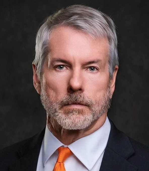 A portrait of Michael Saylor, executive chairman of Strategy (formerly MicroStrategy), wearing a dark suit, light blue shirt, and orange tie against a dark background. The image accompanies the news that Strategy purchased an additional 1,666 BTC for $138 million, bringing its total holdings to 847,666 BTC.
