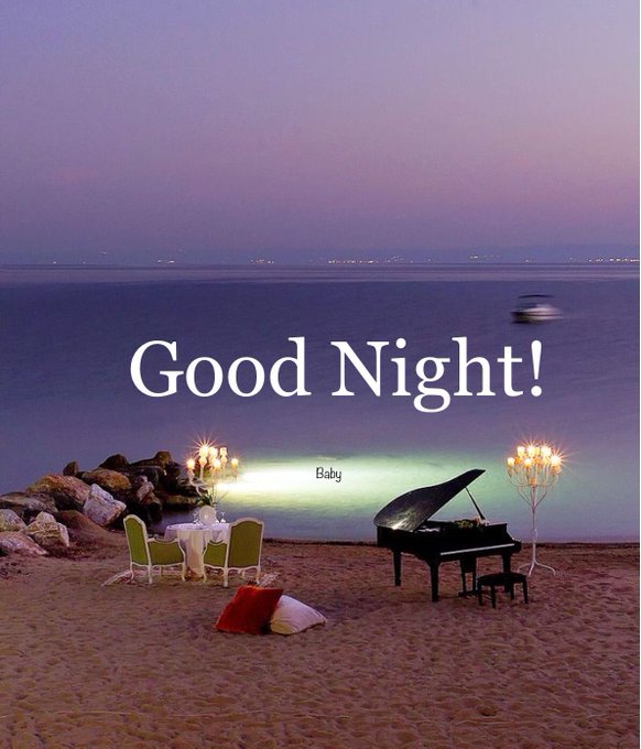 The image features a beautiful beach scene with a piano placed near the water's edge. The piano has candles on top of it, creating an enchanting atmosphere for a romantic evening by the sea. In front of the piano, there are two chairs and a dining table set up, suggesting that this could be a special dinner or a date at the beach. The image also contains text that reads "Good Night!" and "Baby", which might be related to a special occasion or celebration for someone's baby.
