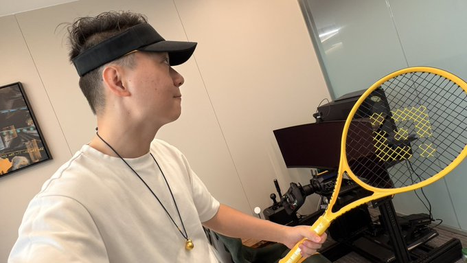 The image features a man holding a yellow tennis racket with a smile on his face. The caption of the photo reads "Thank you @binancezh for the Dragon Boat Festival gift! So special love it so much! How do you get me so well, knowing I want to learn tennis next? I heard playing tennis is pretty similar to playing golf, let'