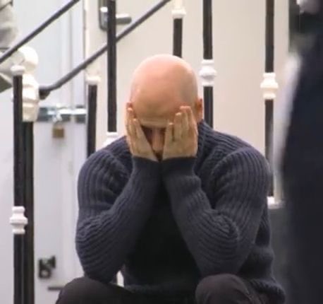 A bald man in a dark gray sweater sits on a staircase, covering his face with both hands in a gesture of despair or exhaustion. The image visually reflects the post's tone of frustration and defeat, as the text laments missing out on crypto investments (CT, Stake, Moonpay) and urges giving up.