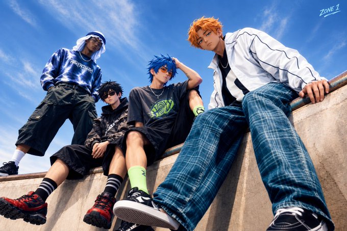 Four young men pose in colorful streetwear fashion against a blue sky, with a "ZONE 1" watermark in the upper right corner.
