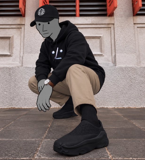 A person squatting on a sidewalk wearing a black hoodie, khaki pants, black sneakers, and a black cap, with their face and hands stylized as a cartoonish gray drawing.