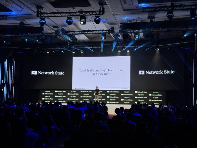 The image shows a conference stage labeled "Network State" with a slide reading "Zcash is the one they'd have to ban. And they can't," with a speaker addressing a large audience. The scene relates to the post's themes of censorship-resistant digital assets, illustrating the argument about privacy-focused cryptocurrencies like Zcash and the platform-attorney ties to @winklevosscap.