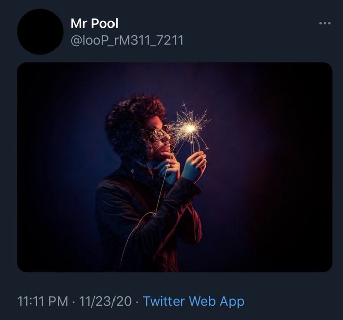 A tweet from user 'Mr Pool' (@looP_rM311_7211) posted at 11:11 PM on 11/23/20, featuring an artistic photo of a person wearing a masquerade mask holding a glowing sparkler.