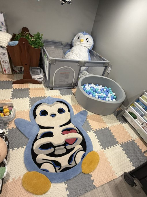 A custom Skeleton Penguin rug lies on a foam mat in a cozy room filled with Pudgy Penguins plush toys and a ball pit, showcasing the prize up for grabs in the @pudgypenguins mystery box redemption campaign ending September 1.