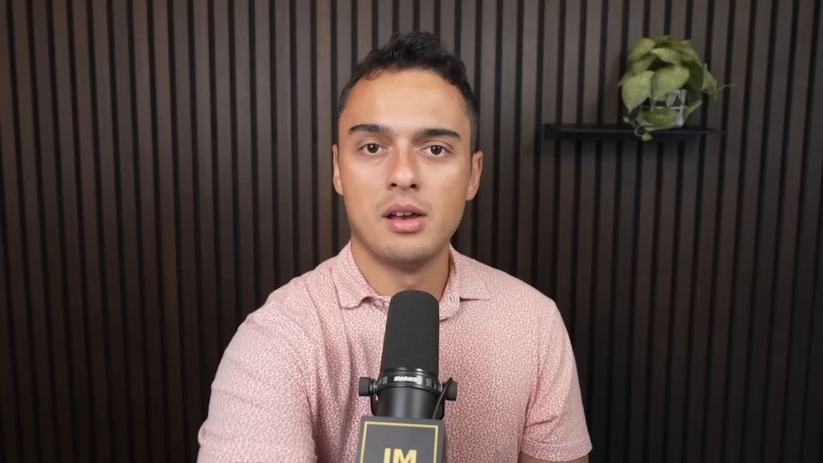 The image shows a man wearing a pink shirt, sitting at a microphone with his hands on his lap while talking into it. The background features a brown wall with a plant placed behind him. There are also two potted plants visible in the scene - one near the top left corner and another towards the right side of the image. The post includes text that reads "The Bittensor chain is doing something no ecosystem should ever do to itself. Every single day, it wakes up and punches its own subnets in the face. One of the most experienced operators in the ecosystem just explained exactly why this has to stop and what Root Reborn is".