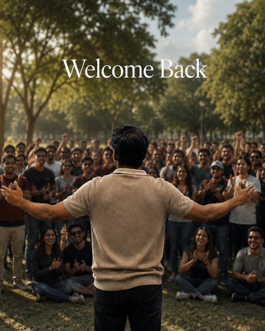 A person with their back to the camera spreads their arms wide, facing a large crowd of cheering people outdoors, with the text 'Welcome Back' displayed prominently.