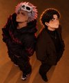 Two anime-style characters, one with a skull-like mask and the other in a school uniform, stand together in a dimly lit setting.