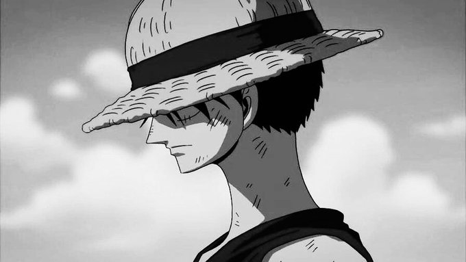 A black-and-white anime-style image shows a side profile of a character wearing a straw hat, cast in dramatic shadow with clouds in the background. The post's theme of "touching grass" pairs with the iconic straw hat, a popular meme symbol associated with the phrase.