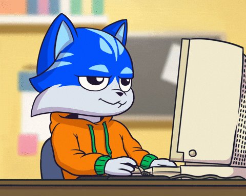 The image features a cartoon cat sitting at a desk with an open computer monitor, likely using it for work or entertainment purposes. The cat appears to be wearing a hoodie and has a blue mask over its eyes, giving it a unique appearance. The text "We know which one it is right $TOSHI" suggests that the image might be related to a post about cats or a similar topic.