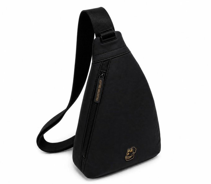 A black triangular sling bag with an adjustable shoulder strap, featuring a side zipper and the text "COLLECTORS COLLECT" on the zipper pull, along with a small gold fist logo near the bottom. The post celebrates the "APE BAG," likely referring to this limited-edition accessory from Bape or a similar streetwear brand.