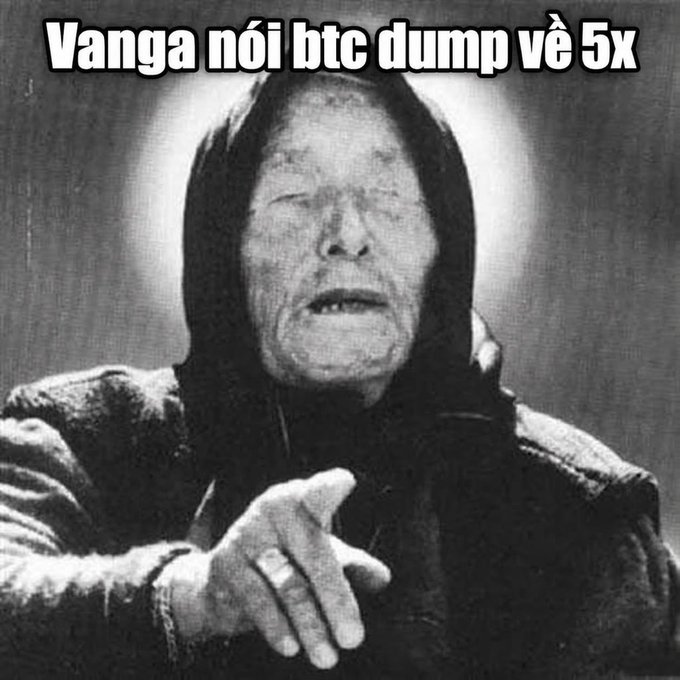 A black and white meme image of an elderly person in a hooded garment pointing downward, with the text 'Vanga nói btc dump về 5x' (Vanga says BTC dumps 5x).