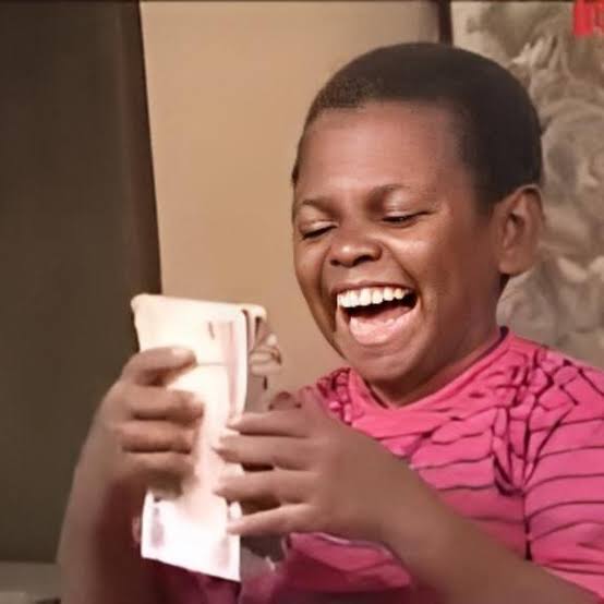 The image features a young boy wearing a pink shirt sitting down while holding a stack of money, including $WKC bills. The caption reads "Aside the fact that I'm holding $PHT for holding $MARS Smart move!", which suggests that the boy is making an unconventional choice to hold onto his money rather than using it immediately or depositing it in a bank account.