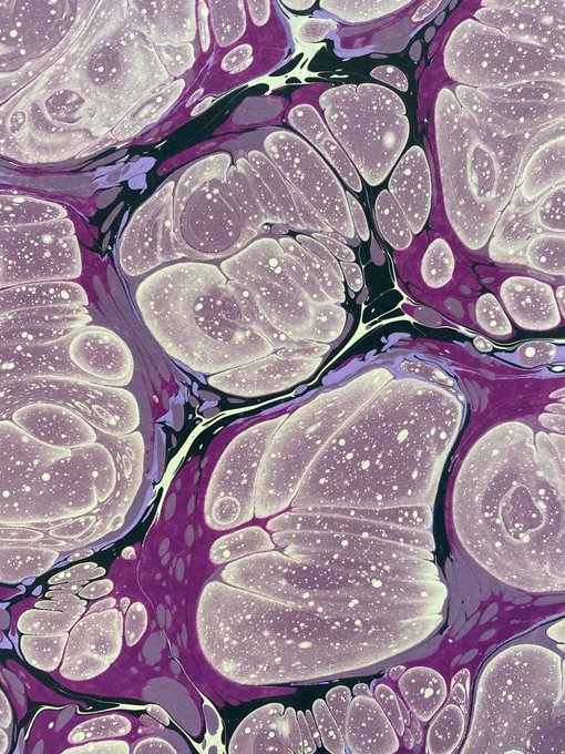 An abstract purple and white marbled texture with cellular, bubble-like patterns and dark veins running throughout.