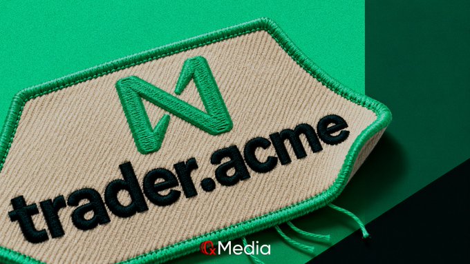 A close-up of an embroidered beige patch with a green border on a green background, displaying a stylized 'M' logo and the text 'trader.acme', watermarked with 'C&Media'.