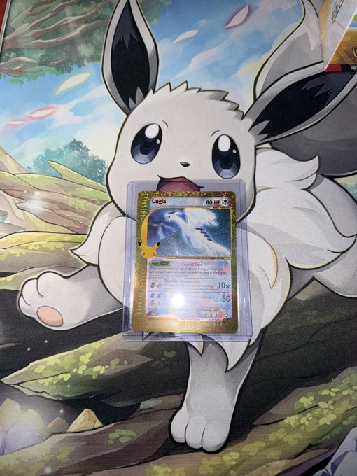 A holographic Lugia Pokémon card displayed against a poster of the white Pokémon Eevee.