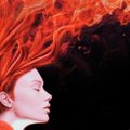 A profile view of a person's face illuminated against a dark background, with an explosion of bright orange and red flames or tendrils erupting dramatically upward from their head.