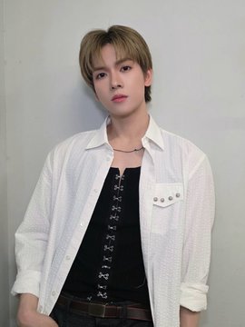 The image features a young man with short hair wearing a white shirt, black belt, and jeans. He has his hands in his pockets while posing for the picture. The background of the photo is plain white, which contrasts with the colorful clothing of the subject. The caption at the bottom of the image reads "POW.pic" and "#YORCH #요치 파우 그리드".