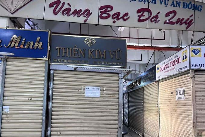 Street view of closed storefronts with metal roller shutters, featuring signs in Vietnamese including 'Vàng Bạc Đá Quý', 'THIÊN KIM VŨ', and 'QUẢNG TRỊNH' jewelry shops.