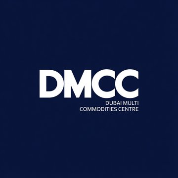 The image features a logo for Dubai Multilingual Commodities Centre (DMCC), which is an organization based in Dubai that focuses on promoting financial inclusion through the use of digital assets, such as tokens and smart contracts. The logo consists of the letters "DMC" written in white against a dark blue background. The text "Dubai Multi Commodities Centre" is also displayed below the "DMC". This logo represents the partnership between Dubai Multilingual Commodities Centre and Tether, which aims to support the adoption of blockchain technology and digital asset initiatives within the DMCC ecosystem.
