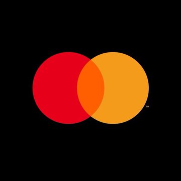 The image features a striking logo for Mastercard that consists of two overlapping circles, one red and one orange, set against a black background. The text "MASSIVE" and "9,000,000,000,000+ payments giant Mastercard explores direct settlement via the XRP Ledger." is also present in the image. This logo represents the company's commitment to innovation and disruption in the financial services industry by exploring new payment methods like Ripple, which can potentially revolutionize the way people make transactions.