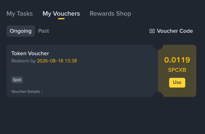 A screenshot of the "My Vouchers" section on Binance showing an ongoing Token Voucher worth 0.0119 SPCXB redeemable by 2026-08-18 13:38, with a yellow "Use" button—relating to the post by suggesting Binance gifted the user a small crypto voucher.