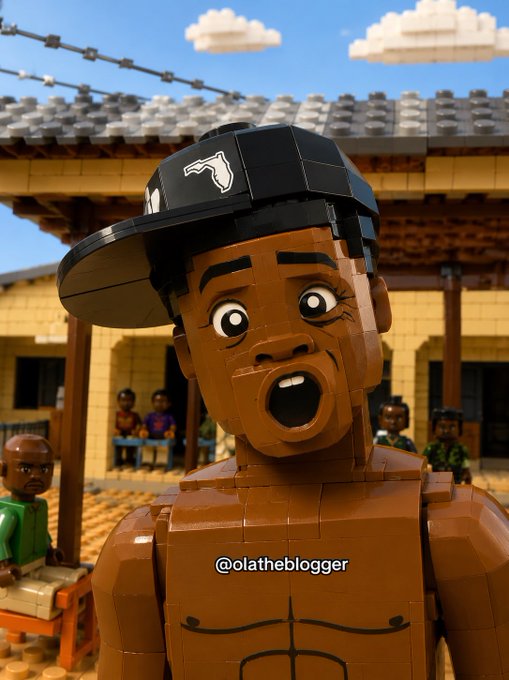 A 3D-rendered LEGO-style character with a muscular torso wears a black cap with a logo, his mouth open in surprise, with the watermark '@olatheblogger' displayed.