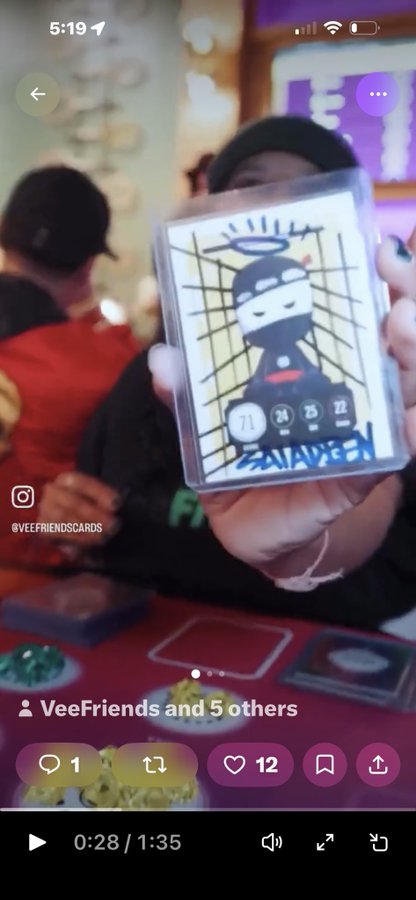 A screenshot of an Instagram video from @veefriendscards showing a person holding up a VeeFriends collectible card with numbers 71, 24, 25, 22 visible, receiving 12 likes.