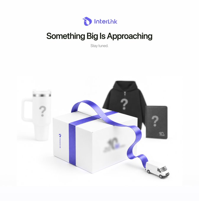An 'InterLnk' promotional image titled 'Something Big Is Approaching' shows a white gift box with a blue ribbon surrounded by mystery items including a tumbler, hoodie, notebook, and a small delivery van.