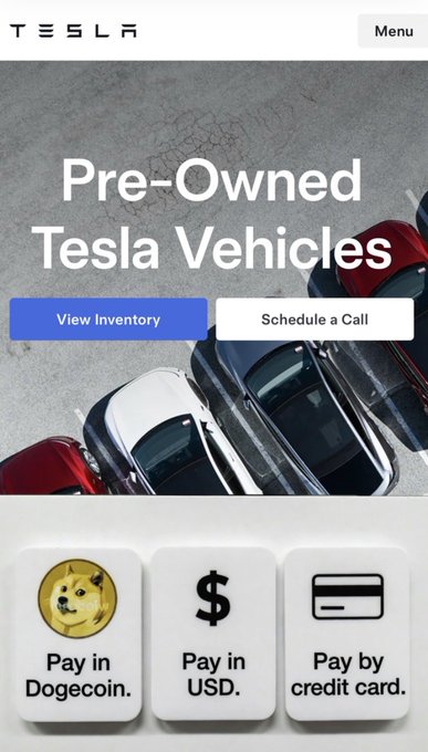 The image shows a screenshot of the Tesla website displaying an advertisement for pre-owned Tesla vehicles. The main focus of this advertisement is the ability to accept Dogecoin as payment. This might be a way for Tesla, or other vehicle manufacturers, to move their stock and appeal to crypto holders who are interested in buying cars but want to use digital currency like Dogecoin instead of traditional money.