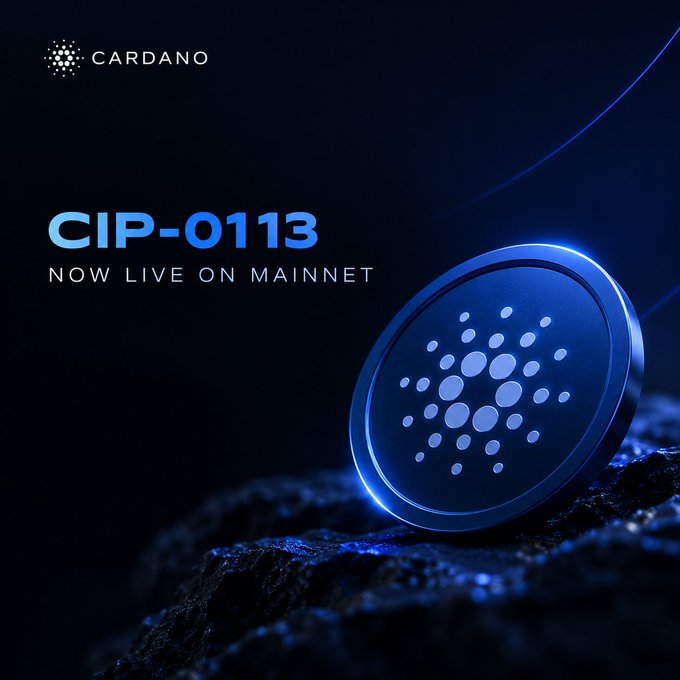 Promotional graphic with the CARDANO logo announcing 'CIP-0113 NOW LIVE ON MAINNET' alongside a 3D render of the blue Cardano coin resting on dark rocky terrain.