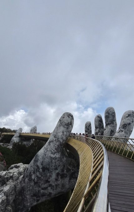 A traveler fulfills their wish to visit Vietnam's Golden Bridge, the famous architectural landmark held aloft by massive stone hands. In the caption, "Golden XRP" appears to be a playful nod tying the bridge's name to their cryptocurrency interests, along with the unusual license plate "589.17" they spotted during their visit.