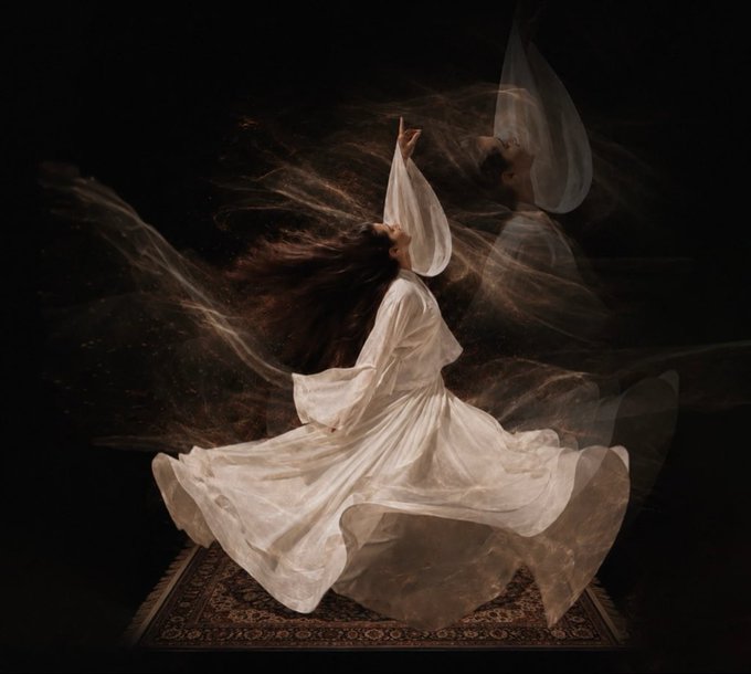 A whirling dervish in a flowing white robe spins against a dark background, with motion blur and smoke-like wisps capturing the spiritual dance.