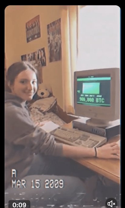 A vintage-style photo dated MAR 15 2009 showing a smiling young woman sitting at a computer displaying "900,000 BTC" on the monitor.