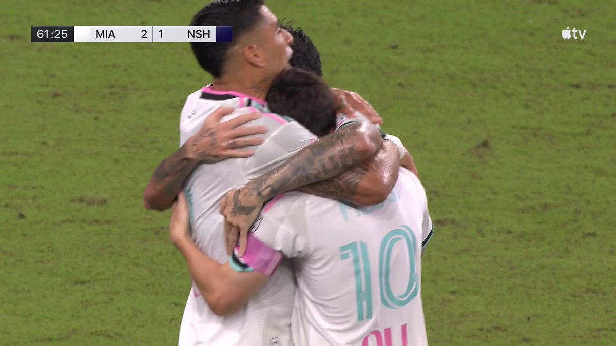 Inter Miami players, including Messi, embrace in celebration on the pitch at 61:25, with the scoreboard showing MIA leading NSH 2-1, following what appears to be one of Messi's signature golazos.