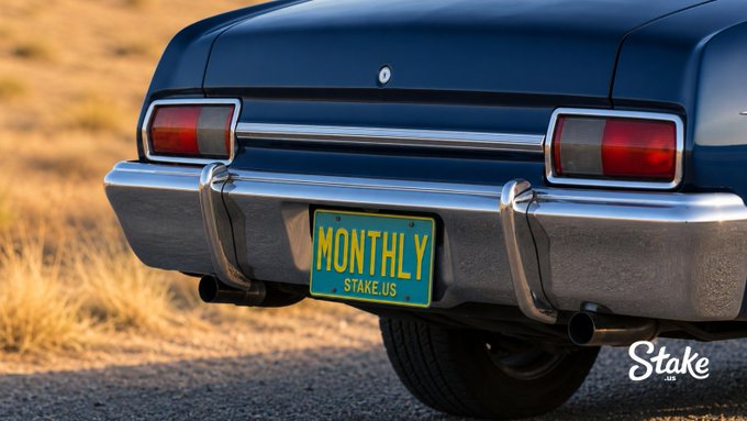The rear of a classic car displays a "MONTHLY" license plate with "STAKE.US" beneath it, set against a dry grassy backdrop, with the "Stake" logo watermark in the bottom right—visually reinforcing the teasing post about the upcoming 2nd Stake Monthly .com users drop.