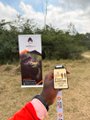 The image shows a person holding up an award, possibly a gold medal or a plaque, while standing next to a banner that says "Over 70 people in attendance for the first ever @btcnairobi_conf fun run More than 10 people finished 21kms on 21st June, 2026 Thank you to everyone who came out to run and walk earlier today 24-26th June". The person holding up the award is wearing a red jacket.
